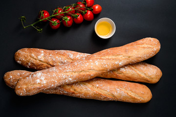 Cherry tomatoes, oil and long loafes with flour. 