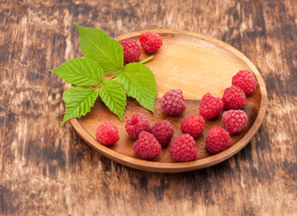 Raspberry on a wooden plate