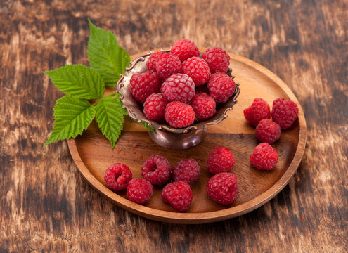 Fresh raspberry in a wooden plate