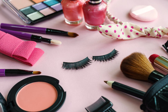 various makeup products and cosmetics isolated on pink