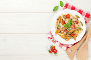 Colorful penne pasta with tomatoes and basil