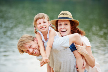 Lachende Familie am Wasser im Sommer