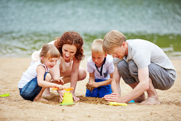 Familie baut Sandburg im Urlaub