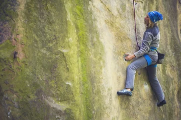 Foto op Plexiglas Alpinisme The girl climbs on the rock.
