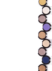 Obraz na płótnie Canvas Eye make up, beauty and cosmetic products - a selection of colored eyeshadow compacts isolated on a white background forming a page border