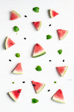 pattern of watermelon slices on wooden white background, top view, flat lay