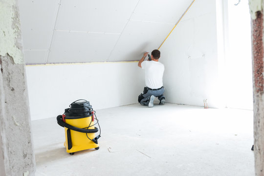 Handwerker schraubt eiine Gibsplatte fest - Trockenbau