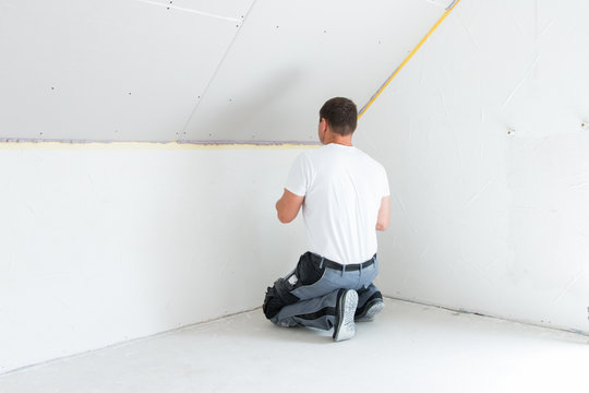 Handwerker schraubt eiine Gibsplatte fest - Trockenbau