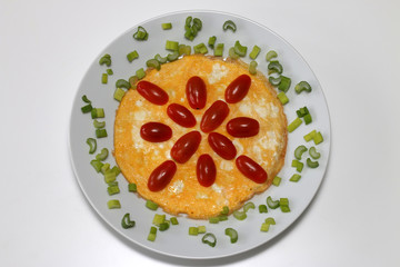 Omelette with cherry tomatoes and green onion, top view, isolated on white background