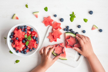 children's hands cooking salad on white table, top view, flat lay