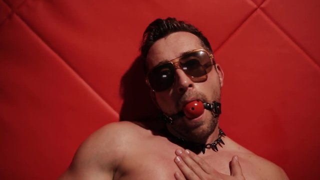 Brutal muscular man in the red room dancing