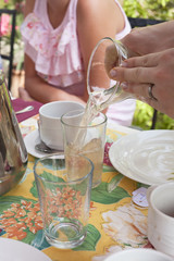Somebody serving water outdoors on a sunny day