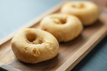 homemade donuts on wooden plate.