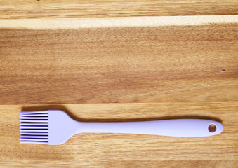 Cooking utensils - a silicone baking pastry brush on a wooden background forming a page border
