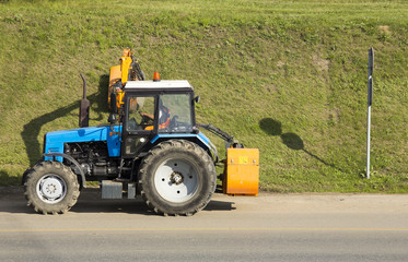 Tractor mowing green grass