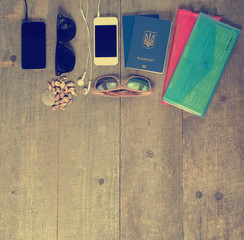 Travel items on wooden table. Passport phone and glasses mock-up
