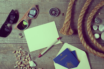 Travel items on wooden table. Notebook blank page mock-up