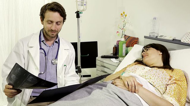 Doctor giving good news to sick female patient in hospital 
