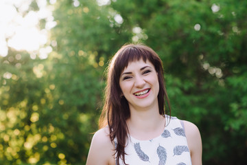 Fototapeta premium Beautiful Young Woman Outdoors. Enjoy Nature. Healthy Smiling Girl in Green Grass.