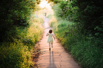 Outdoor portrait of a cute little girl playing in the grass, childhood, happiness, nature, relaxation