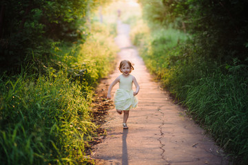 Outdoor portrait of a cute little girl playing in the grass, childhood, happiness, nature, relaxation