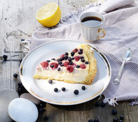 Sunny Photo with a morning breakfast in rustic style. Cheesecake raspberries and blueberries on wooden table.