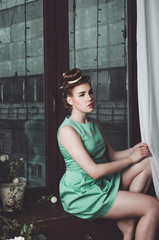 Portrait of the beautiful fasion young woman in cyan green dress with beauty make up, creative hairstyle on brown wooden background. Style photo image  the girl princess, studio shot. Sensual