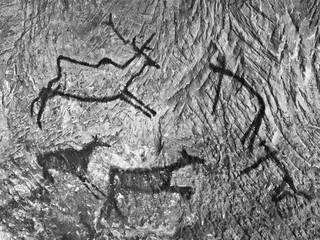 Naklejka premium Black carbon paint of human hunting on sandstone wall,