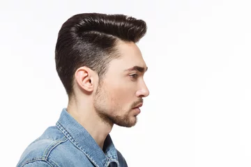  Closeup profile of model man injeans shirt demonstrating his modern hairstyle over white background in studio. Hairdressing concept. © Svyatoslav Lypynskyy