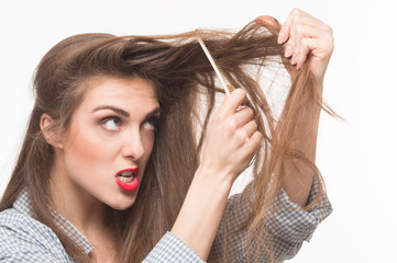 Naklejka premium Portrait of beautiful woman with gorgeous hair. Pretty lady combing her hair with rake comb over white background.