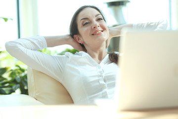 Business woman relaxing with hands behind her head and sitting on a chair