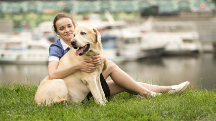 Portrait of a woman with her beautiful dog lying outdoors