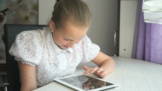 Cute little girl uses a digital tablet computer