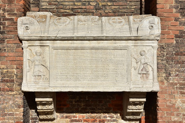 Ancient medieval sarcophagus in Venice. Marble sarcophagus with angels, cross and doge hat symbol, on St John and Paul basilica gothic facade