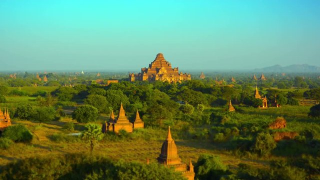 Video 3840x2160 - Tracking, panoramic shot of an enchanting landscape in Bagan, Myanmar, with the spires of ancient, Buddhist temple structures seeming to sprout up in all directions.