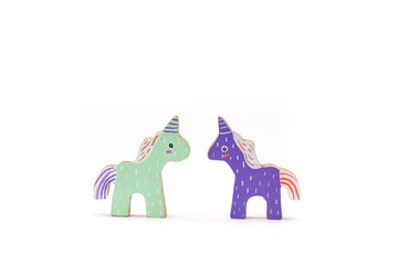 Wooden colorful unicorn horses on white background © Pramemanuch