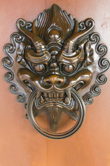Dragon Head Door Knockle On the Light Brown Wallpaper in Chi Lin Temple , Hong Kong