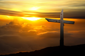 Christian cross over sunset background