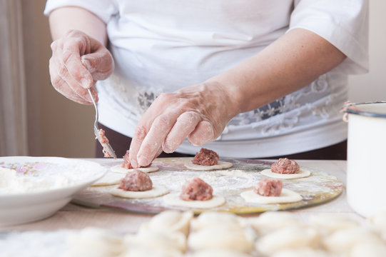 woman cooks dumplings in the kitchen