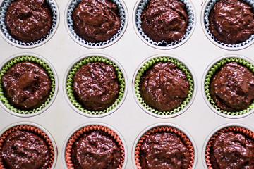 Chocolate muffins dough raw before baking in a muffin tray top view