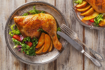 Baked chicken leg, served with roasted potatoes and vegetables.