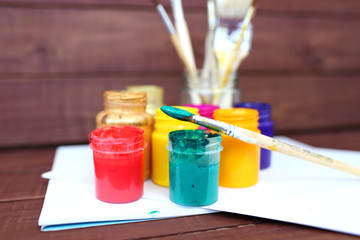 Multicolored plastic cans with paints. Artist workplace background. Art tools. Paints background. Colorful artist palette. Soft toned. Creativity, visual art concept. Art and craft. Closeup