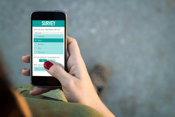 Woman walking and filling online survey form with a smartphone