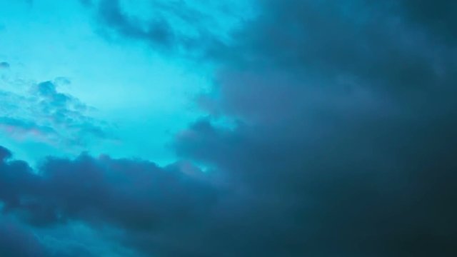 1920x1080 video - Dark, ominous storm clouds appear to struggle against the clear, blue sky as they billow and drift in the wind, in timelapse.