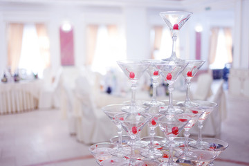 Glass goblets. Pyramid of champagne. The hill glasses wine and cherries. for alcohol. Festive drink. Bartender show. Decorations the Banquet. Small depth field