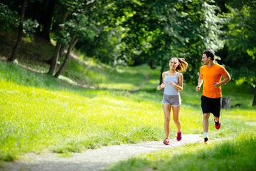 Foto op Plexiglas Atletisch paar joggen in de natuur © NDABCREATIVITY