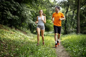 Schilderijen op glas Gezond stel joggen in de natuur © NDABCREATIVITY