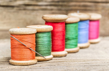 still life of spools of thread on a wooden background
