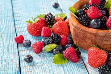Berry fruit in saucer placed on old wooden planks