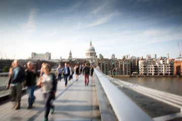 Blurred background of crowd of people on millennium bridge and st pauls cathedral in background,...